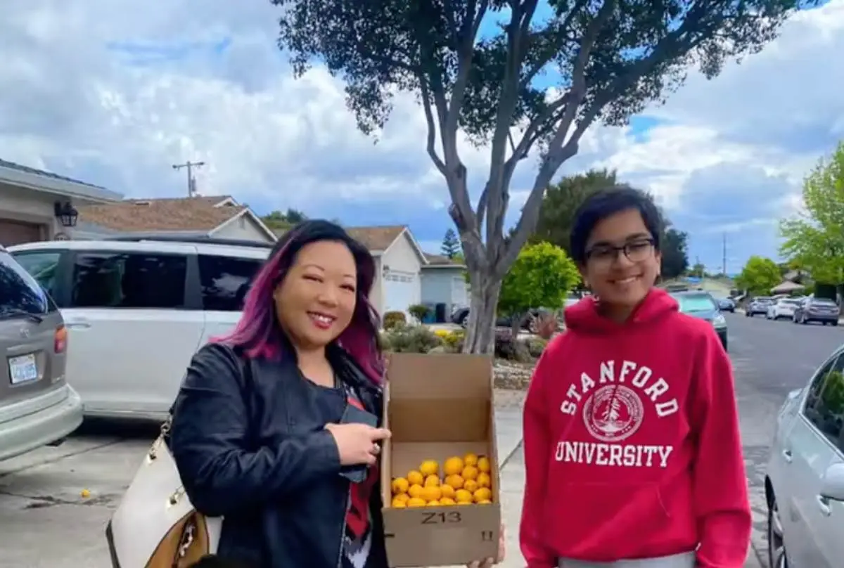 Aadit Mehta with his mother holding a box of harvested loquats